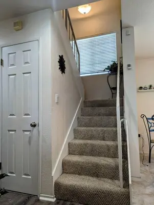 a staircase in a house with a white door at 5 Minutes to South Bay Beaches! Private 2 bedroom 2 bath 2 level home with patio Excellent value! in Torrance