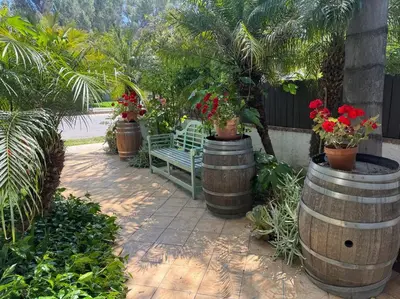 a bench in a garden with flowers in barrels at Mediterranean Villa-Pool Jacuzzi BBQ-Malibu Bliss in Los Angeles