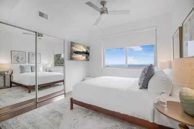 a white bedroom with a bed and a table at Franklin Mediterranean Villa in Los Angeles