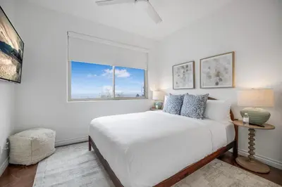 a white bedroom with a large bed and a window at Franklin Mediterranean Villa in Los Angeles