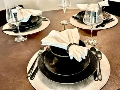 a table with black plates and silverware on a table at Cozy Large 1 Bedroom Condo by UCLA in Los Angeles