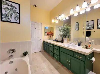 a bathroom with green cabinets and a tub and sink at Spacious studio with two queen beds near Beverlywood 5 minutes to Rodeo Drive in Los Angeles