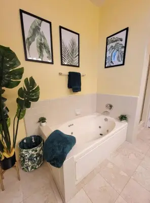 a white bath tub in a bathroom with a plant at Spacious studio with two queen beds near Beverlywood 5 minutes to Rodeo Drive in Los Angeles
