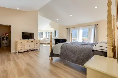 a bedroom with a large bed and a television at Game Room and Deck Modern Frazier Park Home! in Pine Mountain Club