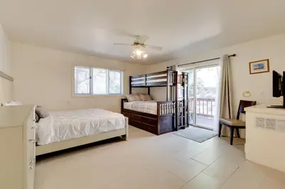 a bedroom with a bed and a balcony at Game Room and Deck Modern Frazier Park Home! in Pine Mountain Club