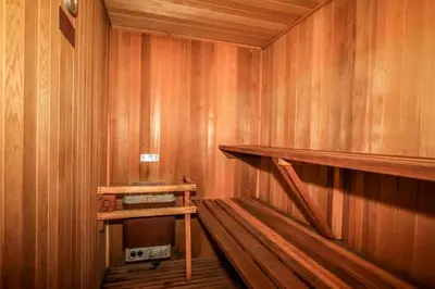 a sauna with a wood paneled wall and a wooden shelf at A Big Olympic Getaway in Big Bear Lake