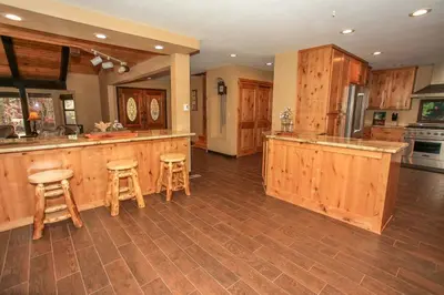 a large kitchen with wooden cabinets and bar stools at Summit Lodge 1 in Big Bear Lake