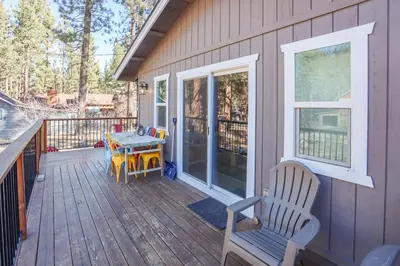 a porch with a table and a chair on a deck at Comet's Cabin in Big Bear Lake