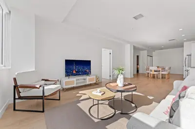 a living room with a couch and a tv at Stylish LA Getaway near Downtown - Prime Location on Wilshire Blvd! in Los Angeles