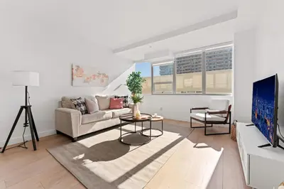 a living room with a couch and a tv at Stylish LA Getaway near Downtown - Prime Location on Wilshire Blvd! in Los Angeles