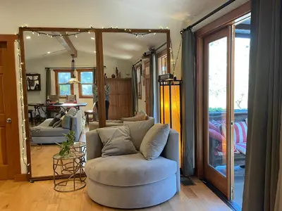 a living room with a chair and a mirror at Sparkling Gem Set Between Mountain and Ocean in Topanga