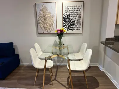 a dining room with a glass table and white chairs at Spacious 1bdrm apartment 10 mins to Cedars-Sinai by car FREE Parking, King bed in Los Angeles