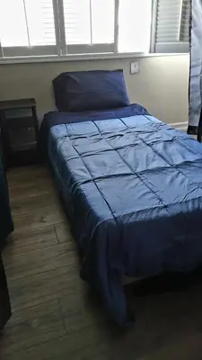 a bed in a bedroom with a blue comforter at Westminster Home in Westminster