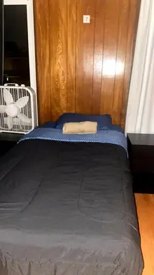 a small bed in a room with a wooden wall at Westminster Home in Westminster