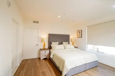 a white bedroom with a bed and a window at New Modern 3BR 3BA Apt in Central Los Angeles with Rooftop & Parking in Los Angeles