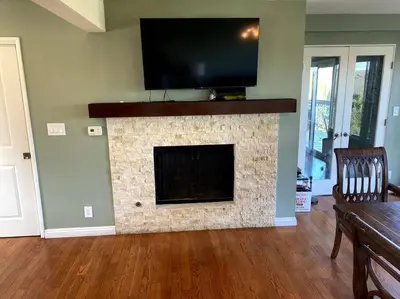 a living room with a fireplace with a flat screen tv at Hilltop Oasis Near Palos Verdes in San Pedro
