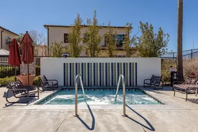 a swimming pool with chairs and a fence at GOODE HOMES Luxury Villa with Community Pool and Spa in Santa Clarita