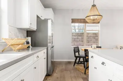 a kitchen with white cabinets and a table with chairs at GOODE HOMES Luxury Villa with Community Pool and Spa in Santa Clarita