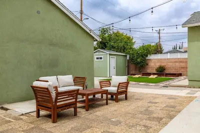 three chairs and a table with pillows on a patio at Goode Homes Luxury Family Home in Granada Hills