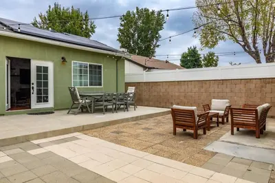 a patio with chairs and a table and a fence at Goode Homes Luxury Family Home in Granada Hills