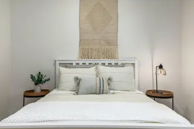a bedroom with a large white bed with two tables at GOODE HOMES Luxury Modern Home with Pool and Spa in Santa Clarita