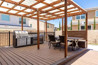 a wooden deck with a grill and a picnic table at GOODE HOMES Luxury Modern Home with Pool and Spa in Santa Clarita