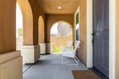 a porch with a chair and an open door at GOODE HOMES Luxury Modern Home with Pool and Spa in Santa Clarita
