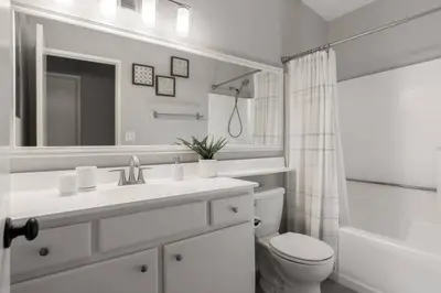 a bathroom with a sink and a toilet and a mirror at GOODE HOMES Luxury Modern Home with Jacuzzi in Santa Clarita