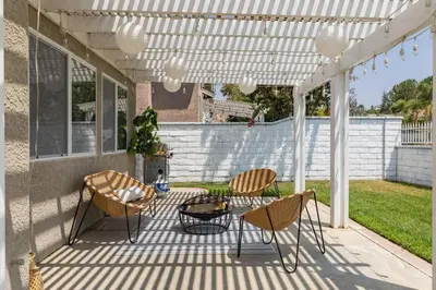 a patio with chairs and a table under a white pergola at GOODE HOMES Luxury Modern Home with Jacuzzi in Santa Clarita