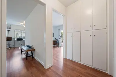 an empty living room with white cabinets and a table at Sawtelle Serenity- Modern Comfort in Los Angeles