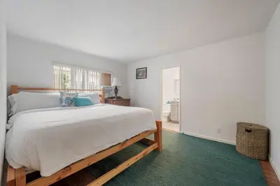 a bedroom with a large bed and a green rug at Sawtelle Serenity- Modern Comfort in Los Angeles