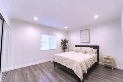 a white bedroom with a bed and a window at Modern LA Home - King Bed, Outdoor Living, Firepit in Los Angeles