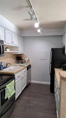 a kitchen with white cabinets and a black refrigerator at 2bdr Bluff Heights Condo walking distance to beach in Long Beach