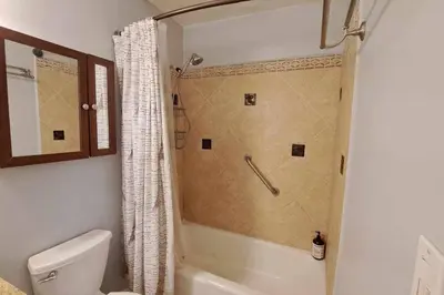 a bathroom with a shower and a toilet and a tub at 2bdr Bluff Heights Condo walking distance to beach in Long Beach