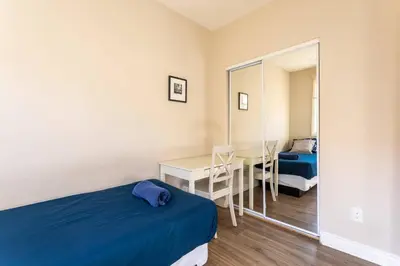 a bedroom with a bed and a desk and a mirror at Getaway 4BR Home in the Heart of LA in Los Angeles