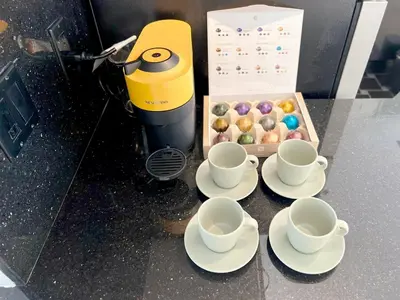 three cups and saucers on a counter with a box of donuts at Coastal Retreat Steps from the Santa Monica Beach in Los Angeles