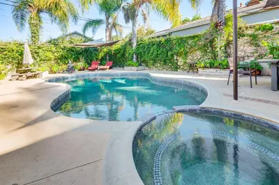 a swimming pool in a yard with palm trees at 4 Mi to Beach Chic Los Angles Home with Patio! in Los Angeles