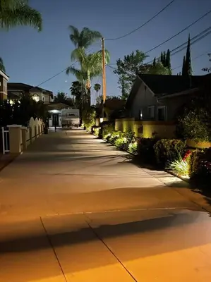 a street with houses and palm trees and a sidewalk at Elegant private studio with private entrance and pool access in San Gabriel