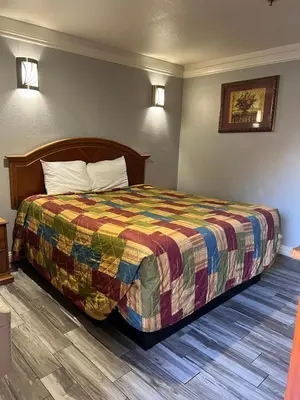 a hotel room with a bed with a colorful quilt at Amber Motel in Inglewood