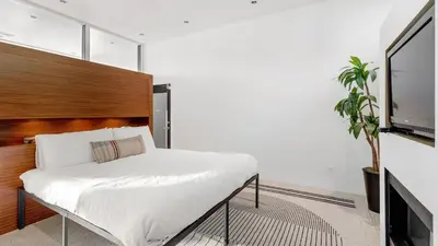 a bedroom with a bed and a flat screen tv at Kings Road West Hollywood Luxury Pool Views Firepit Modern Design in Los Angeles