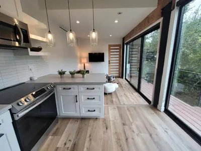 a kitchen with white cabinets and large windows at Sumac in Los Angeles