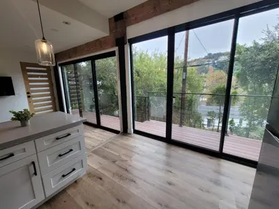a kitchen with large windows and a large kitchen with wooden floors at Sumac in Los Angeles