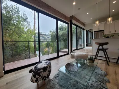 a living room with large windows and a table at Sumac in Los Angeles