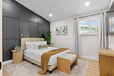 a bedroom with a large bed with a black headboard at Modern Anaheim Stay- Minutes to Disney& Family Fun in Anaheim