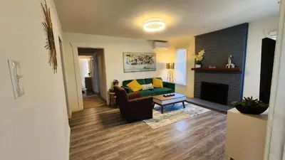 a living room with a green couch and a fireplace at LAX House Near SoFi Stadium, Intuit Dome, YouTube Theater, The Kia Forum, Beaches in Inglewood