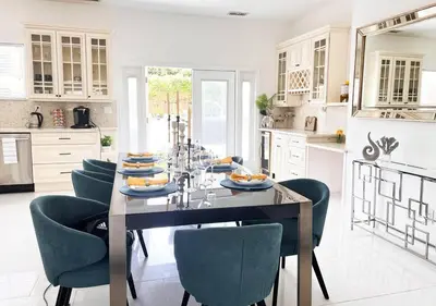 a kitchen with a table with blue chairs at Luxury Oasis in Central Encino w Pool & Spa Topeka in Los Angeles