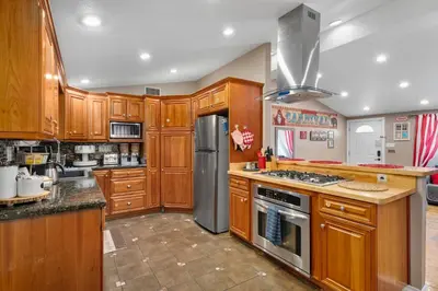 a kitchen with wooden cabinets and a stainless steel refrigerator at Carnival Dream by OC Adventure Homes in Orange