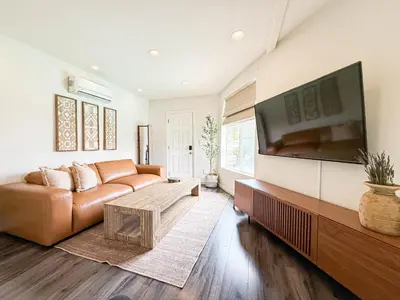 a living room with a couch and a large flat screen tv at Charming Studio Oasis with Pool Near SoFi - MKLAD4 in Los Angeles