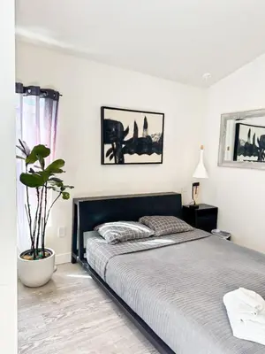 a bedroom with a large bed and a potted plant at Charming Poolside ADU Near SoFi Stadium - MK3LAD in Los Angeles