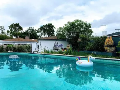 a swimming pool with a pool toy in the water at Charming Poolside ADU Near SoFi Stadium - MK3LAD in Los Angeles
